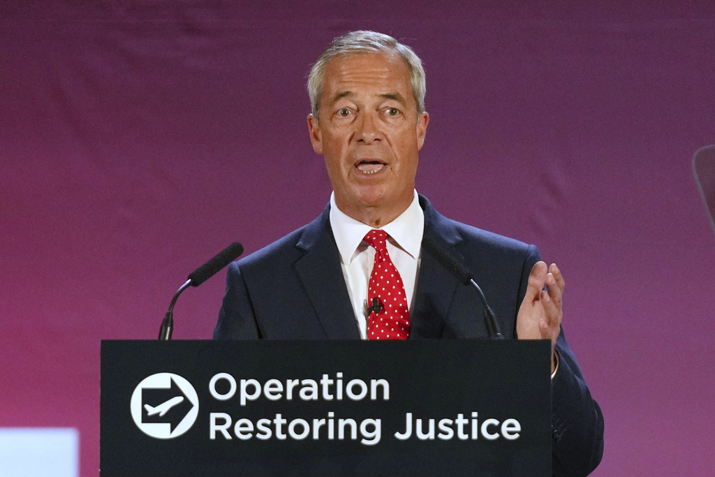 British Reform party leader Nigel Farage addresses journalists during a press conference in a hangar at Oxford Airport in Kidlington, England, Tuesday, Aug. 26, 2025.(AP Photo/Joanna Chan)