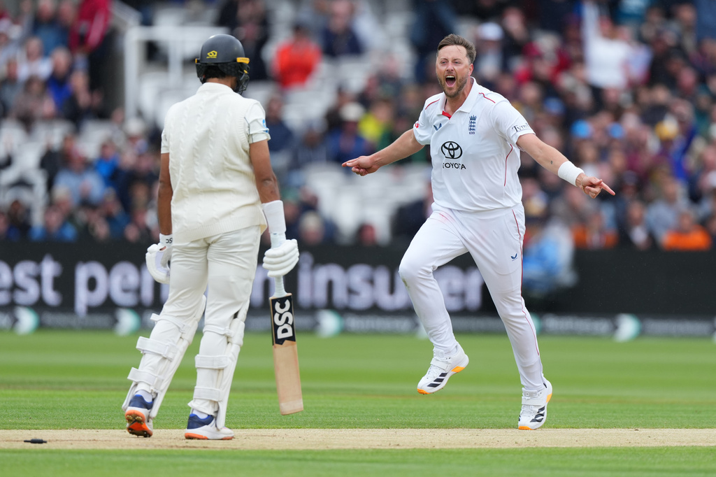 England's Ollie Robinson, right, celebrates the dismissal of New Zealand's Rachin Ravindra, left, during the third day of the Test match between England and New Zealand at Lord's cricket ground in London, Saturday, June 6, 2026. (AP Photo/Kirsty Wigglesworth)