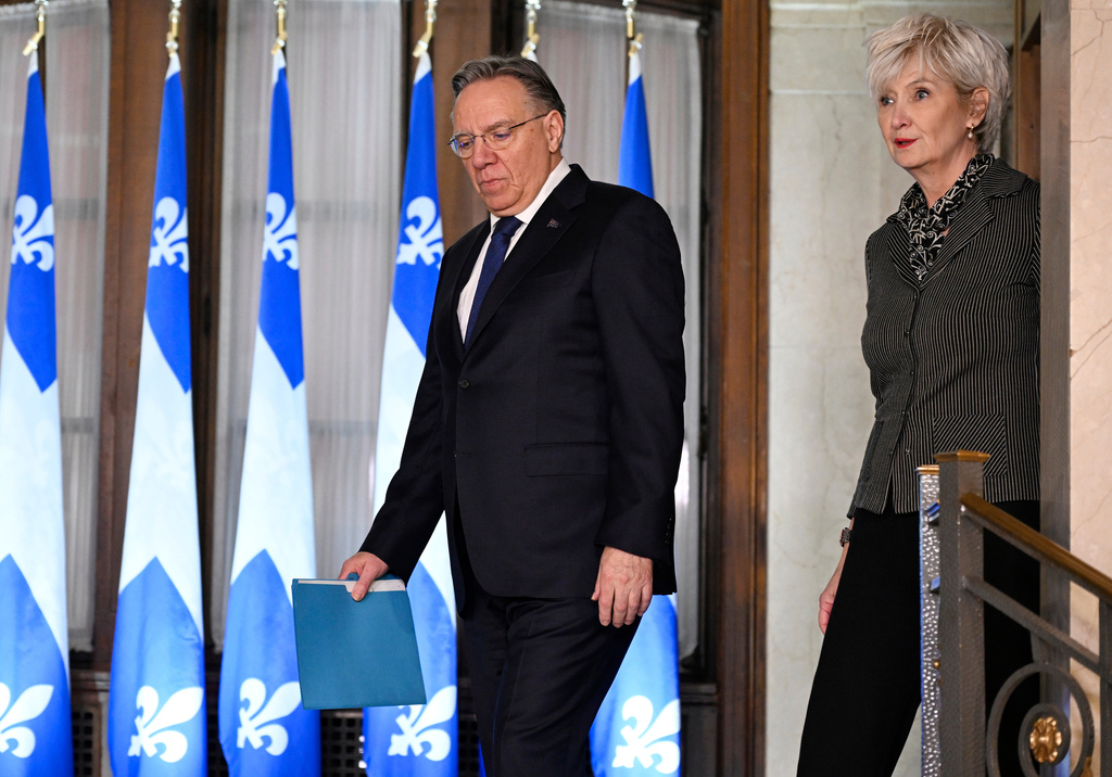 Quebec Premier Francois Legault and his wife, Isabelle Brais, walk to a news conference to announce his resignation in Quebec City, on Wednesday, Jan. 14, 2026. (Jacques Boissinot/The Canadian Press via AP)