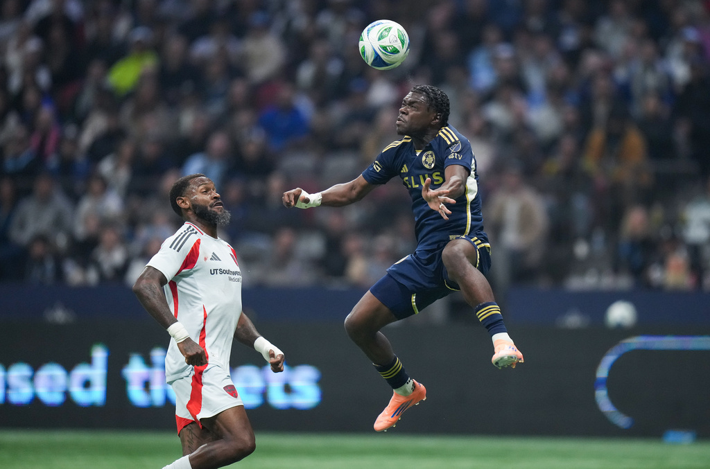 Vancouver Whitecaps' Emmanuel Sabbi, right, and FC Dallas' Sebastien Ibeagha, left, vie for the ball during the second half of an MLS soccer match in Vancouver, British Columbia, Saturday, Oct. 18, 2025. (Darryl Dyck/The Canadian Press via AP)