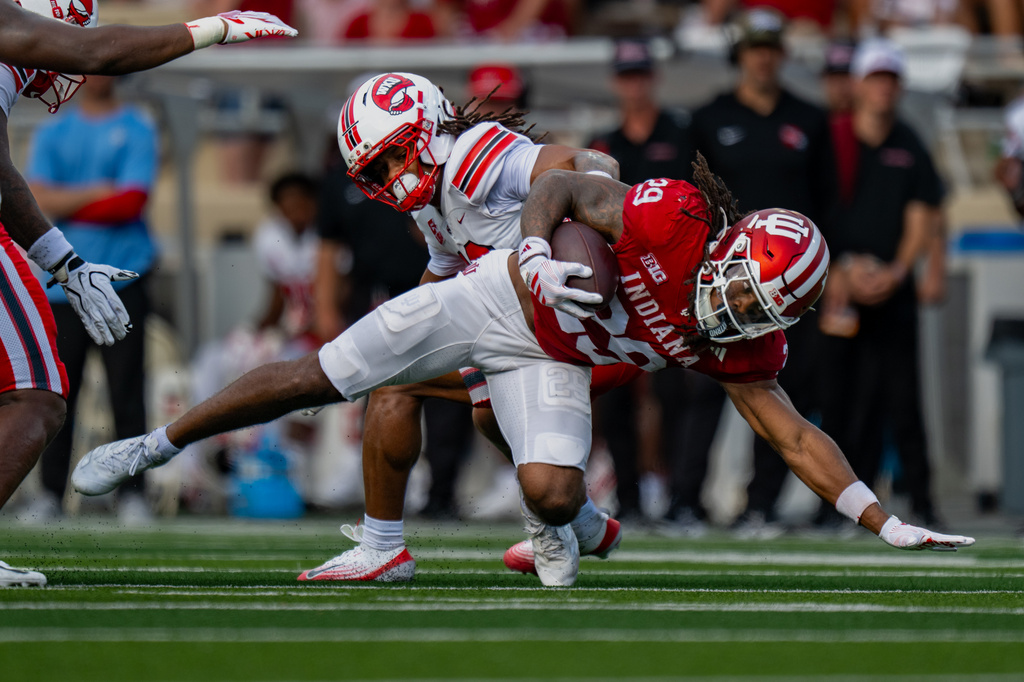 Indiana running back Lee Beebe Jr. (29) stretches for first-down yardage as Western Kentucky defensive back Jacob Cosby-Mosley (19) defends during the first half of an NCAA college football game, Saturday, Sept. 19, 2026, in Bloomington, Ind. (AP Photo/Doug McSchooler)