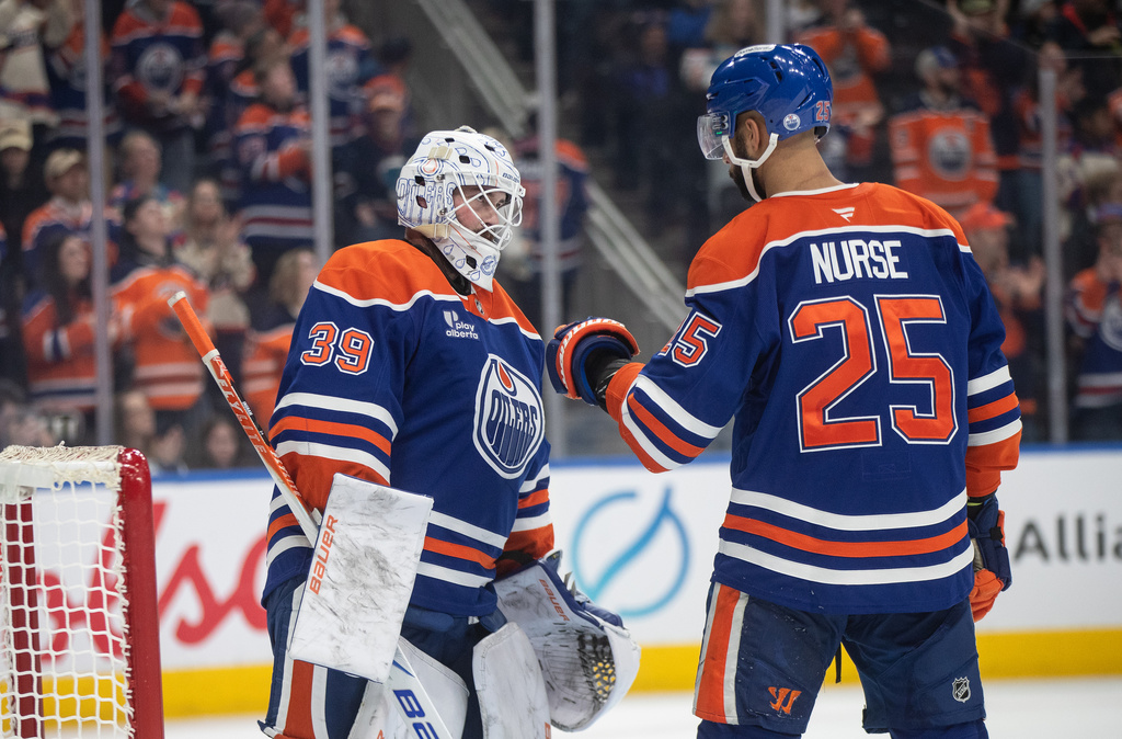 Edmonton Oilers' goalie Connor Ingram (39) and Darnell Nurse (25) celebrate the win over the St. Louis Blues during third period NHL hockey action, in Edmonton on Sunday, Jan. 18, 2026. (Jason Franson/The Canadian Press via AP)