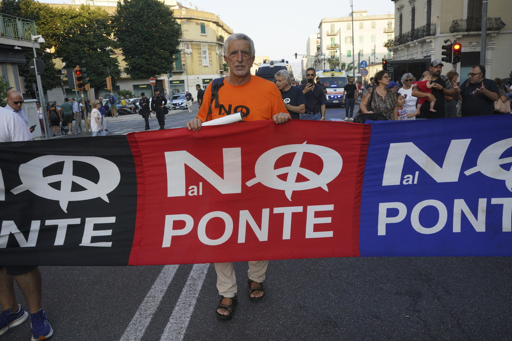 People hold a banner during a demonstration against the bridge in Messina, Italy on Saturday, Aug. 9, 2025 (Francesco Saya/LaPresse via AP)