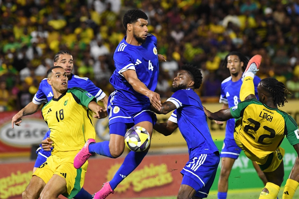Curacao's Roshon Van Eijma, in the air, fights for the ball with Jamaica's Gregory Leigh, right, and Jonathan Russell during a World Cup 2026 qualifying soccer match in Kingston, Jamaica, Tuesday, Nov. 18, 2025. (AP Photo/Collin Reid)