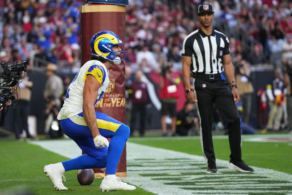 Los Angeles Rams wide receiver Puka Nacua, left, reacts after scoring a touchdown against the Arizona Cardinals in the first half of an NFL football game Sunday, Dec. 7, 2025, in Glendale, Ariz. (AP Photo/Rick Scuteri)