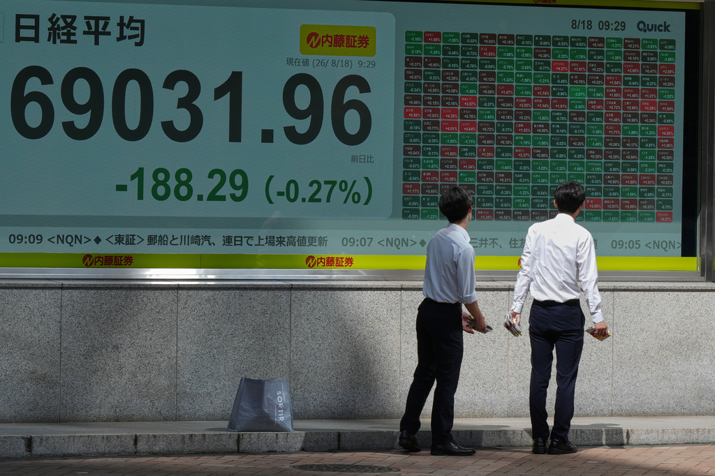 People look at an electronic stock chart board showing Japan's Nikkei index at a securities firm Tuesday, Aug. 18, 2026, in Tokyo. (AP Photo/Eugene Hoshiko)