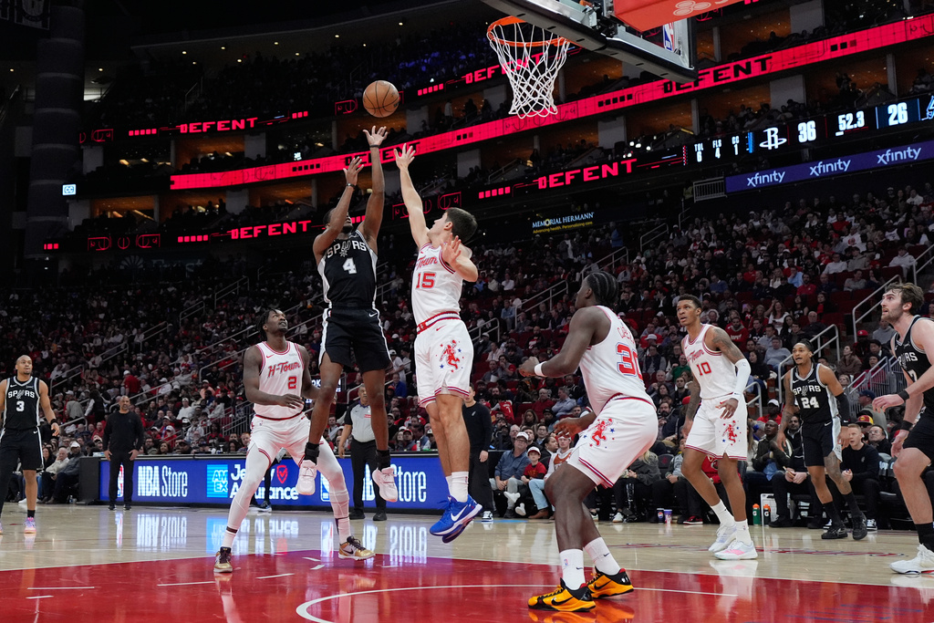 San Antonio Spurs guard De'aaron Fox (4) shoots against Houston Rockets guard Reed Sheppard (15) during the first half of an NBA basketball game in Houston, Wednesday, Jan. 28, 2026. (AP Photo/Ashley Landis)
