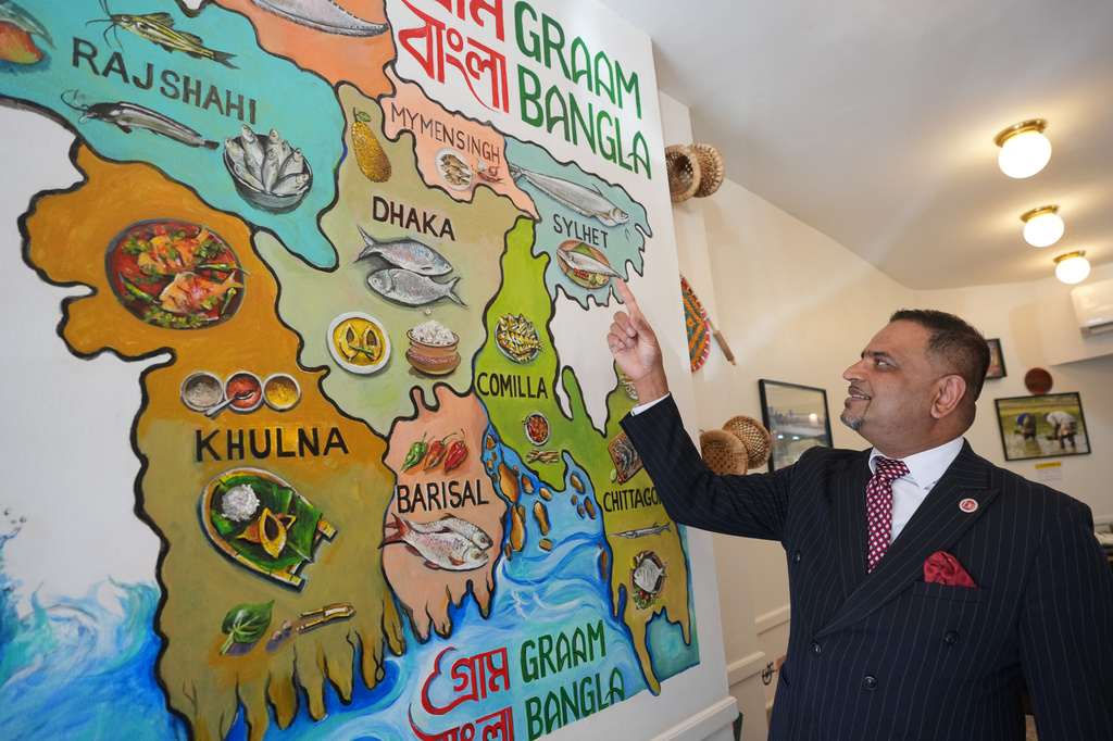 Oli Khan, the senior vice president of the Bangladesh Caterers Association UK, shows a map at a Bangladeshi restaurant in London, Thursday, June 18, 2026. (AP Photo/Kin Cheung)