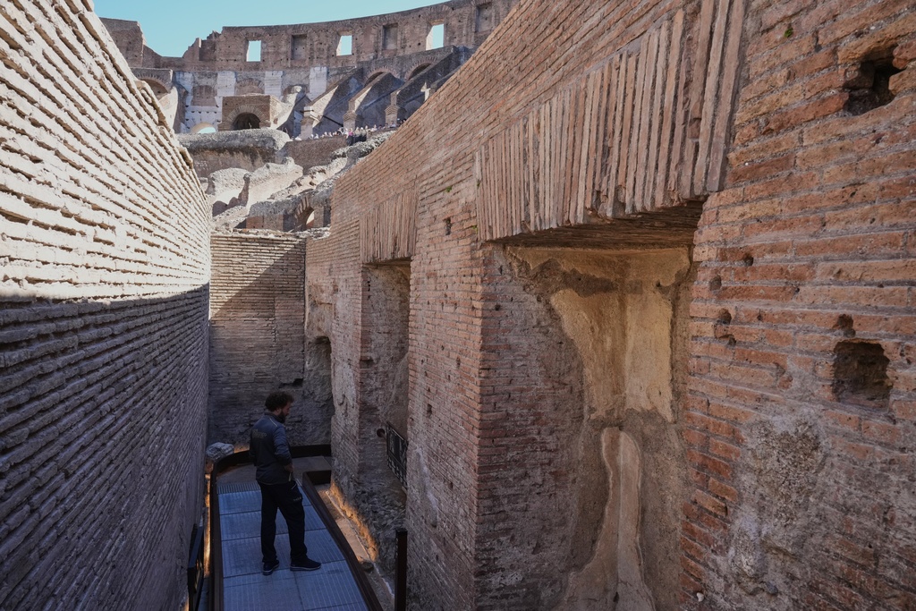 A worker walks in the so-called 'Passage of Emperor Commodus', a newly restored tunnel ancient Roman emperors would use to enter the Colosseum unseen and protected, that will open to visitors at the end of the month, in Rome, Wednesday, Oct. 8, 2025. (AP Photo/Andrew Medichini)
