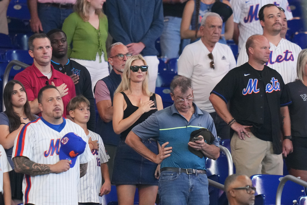 Ivanka Trump, center, stands for the national anthem before a baseball game between the Miami Marlins and the New York Mets, Sunday, Sept. 28, 2025, in Miami. (AP Photo/Lynne Sladky)
