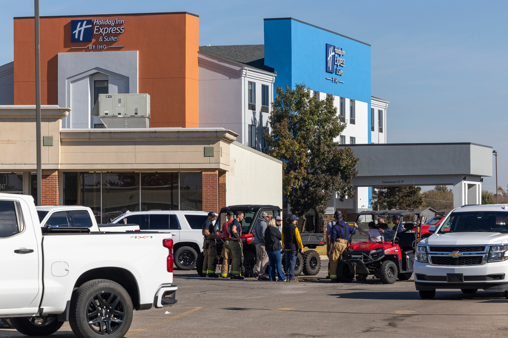 Business owners and first responders gather in a shopping center parking lot near the scene of an ammonia spill in Weatherford, Okla. after the shelter in place was lifted on Thursday, Nov. 13, 2025. (AP Photo/Alonzo Adams)