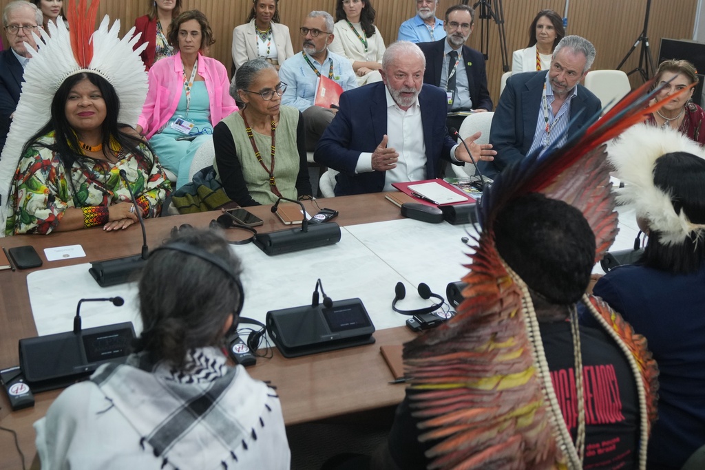 Brazil President Luiz Inacio Lula da Silva, second from right, sits with Brazil Indigenous Peoples Minister Sonia Guajajara, left, Marina Silva, Brazil environment minister, second from left, and André Corrêa do Lago, COP30 president, right, as they speak with members from Indigenous groups at the COP30 U.N. Climate Summit, Wednesday, Nov. 19, 2025, in Belem, Brazil. (AP Photo/Andre Penner)