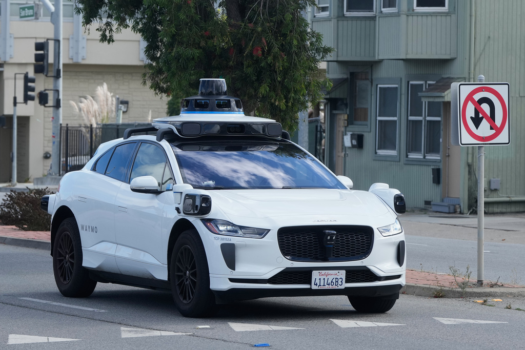 A Waymo vehicle drives past a No U-Turn sign in San Bruno, Calif., Tuesday, Sept. 30, 2025. (AP Photo/Jeff Chiu)