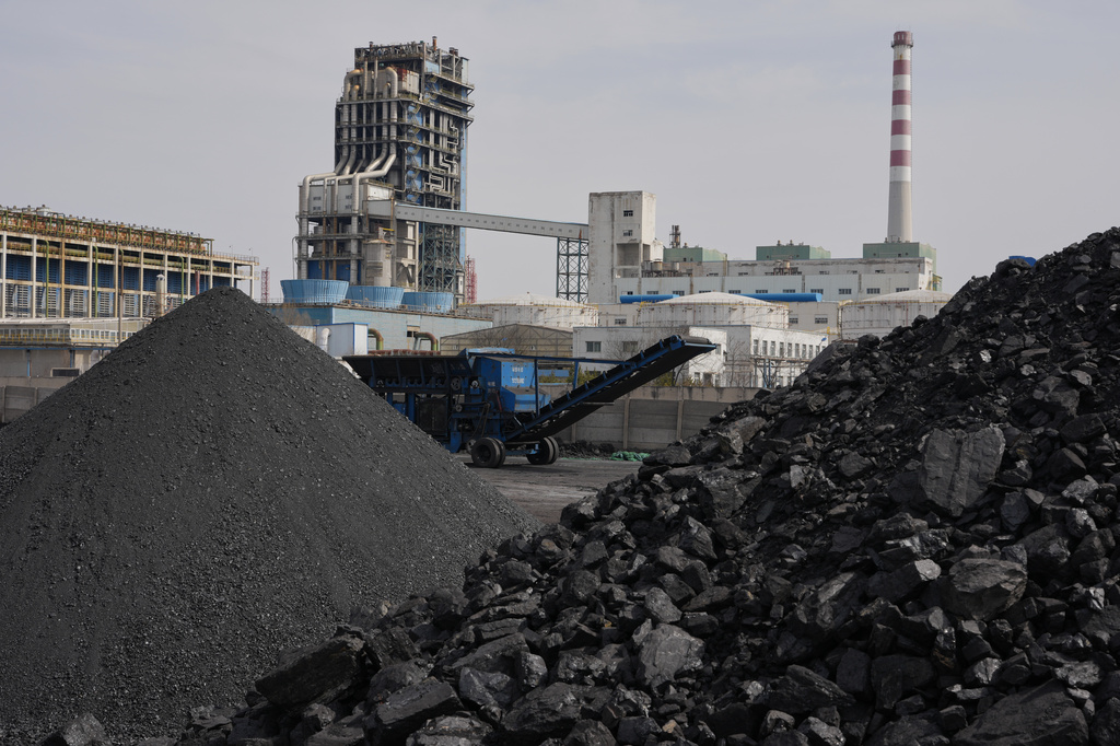 FILE - Piles of coal sit near a chemical plant in Datong, China, March 14, 2026. (AP Photo/Ng Han Guan, File)