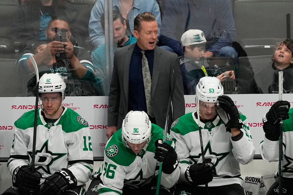 Dallas Stars head coach Glen Gulutzan, standing, reacts behind players during the third period of an NHL hockey game against the San Jose Sharks in San Jose, Calif., Thursday, Dec. 18, 2025. (AP Photo/Jeff Chiu)