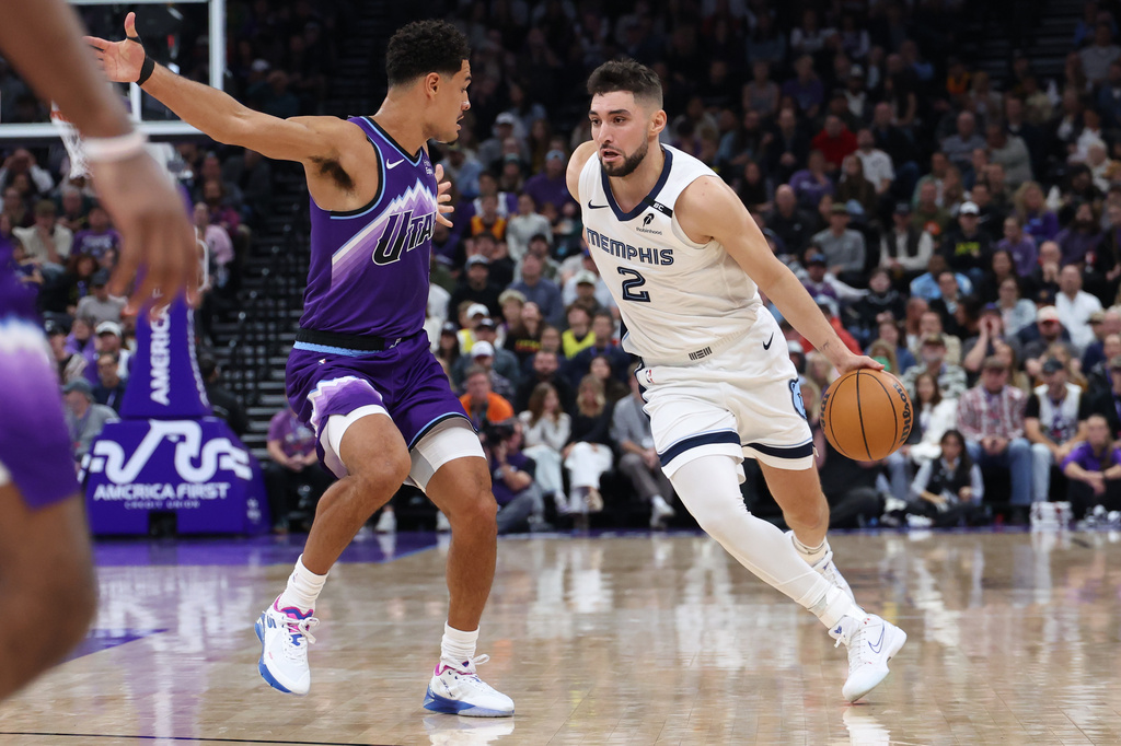 Memphis Grizzlies guard Ty Jerome (2) drives to the basket against Utah Jazz guard Josh Green, left, during the first half of an NBA basketball game, Monday, Oct. 26, 2026, in Salt Lake City. (AP Photo/Rob Gray)