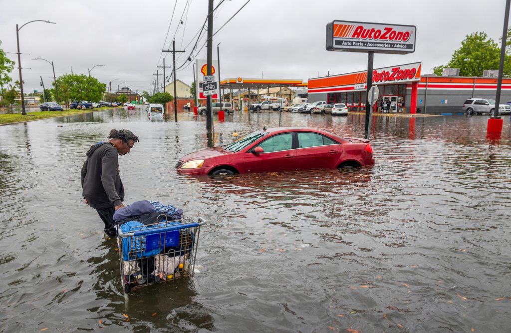 FILE - A person carries their belongings down a flooded street in New Orleans on April 10, 2024. (Chris Granger/The Times-Picayune/The New Orleans Advocate via AP)