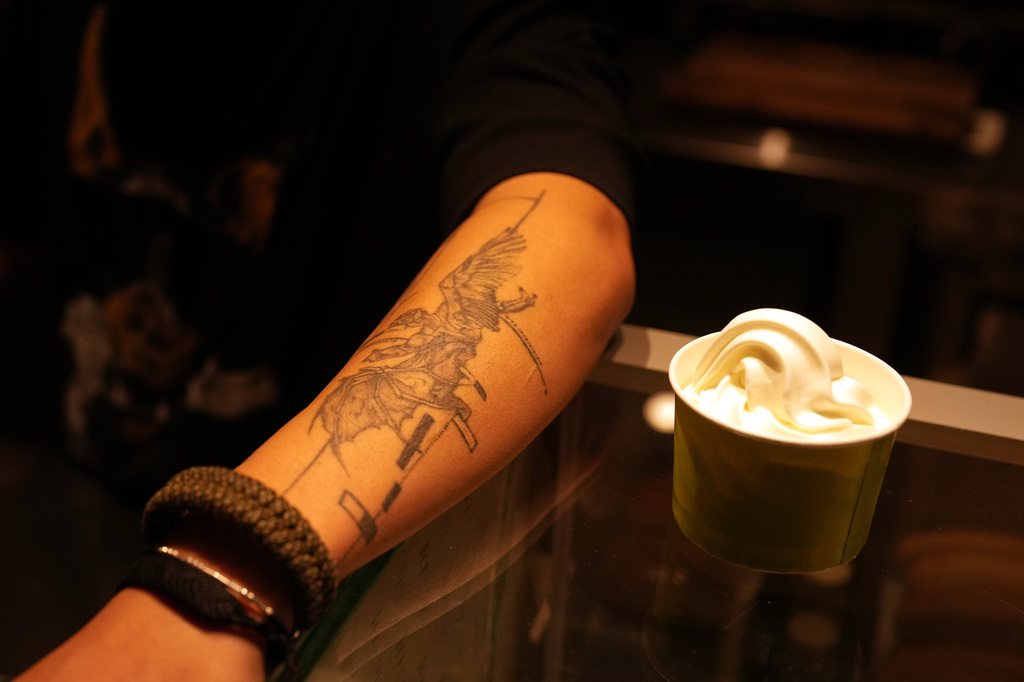 A café worker displays his tattoo for a photo in a café in central Tehran, Iran, Wednesday, April 8, 2026. (AP Photo/Francisco Seco)