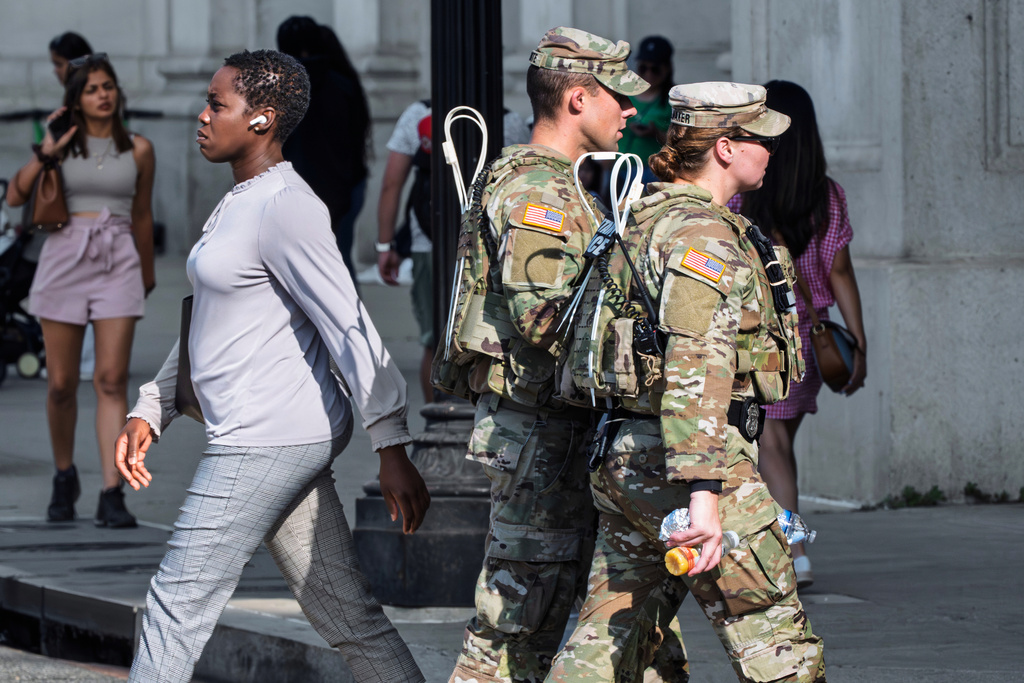 National Guard personnel keep watch as travelers arrive at the entrance to Union Station near the Capitol, in Washington, Thursday, Aug. 14, 2025. (AP Photo/J. Scott Applewhite)