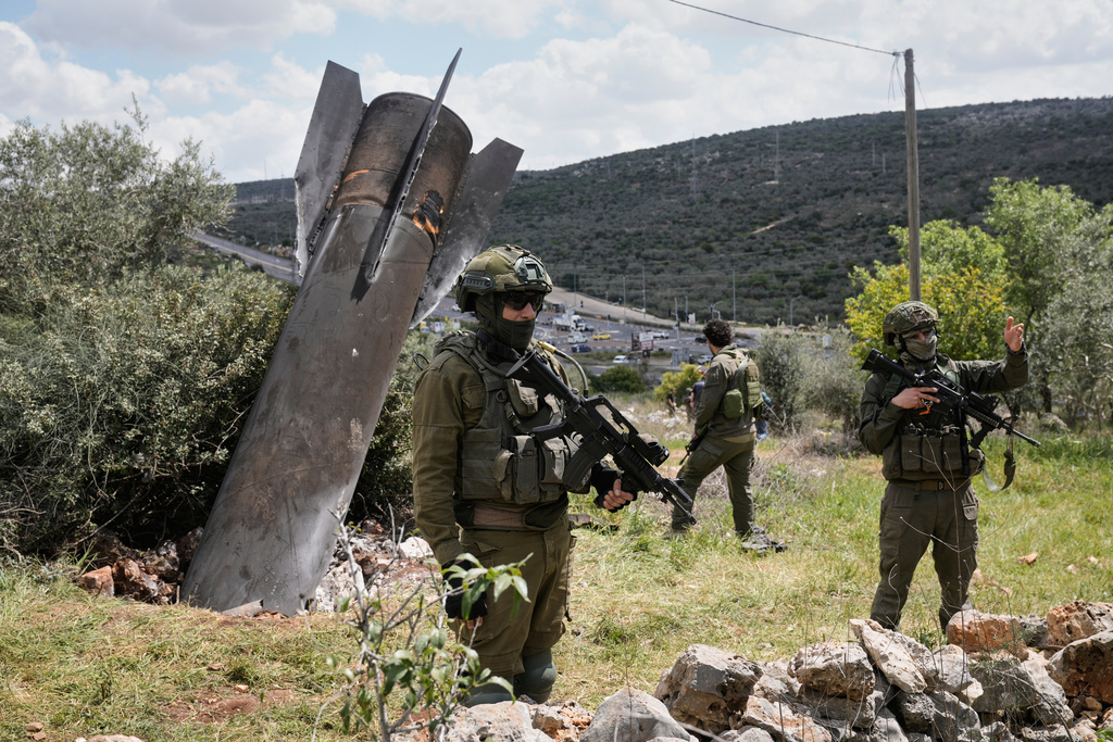 Israeli soldiers secure the site where an Iranian missile wreckage landed in the West Bank village of Kifl Haris Tuesday, March 24, 2026. (AP Photo/Majdi Mohammed)