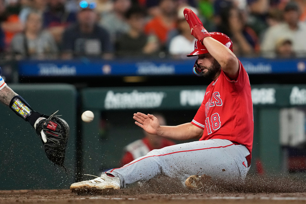 Los Angeles Angels' Nolan Schanuel scores ahead of a throw to Houston Astros catcher Christian Vazquez during the third inning of a baseball game in Houston, Sunday, March 29, 2026. (AP Photo/Ashley Landis)