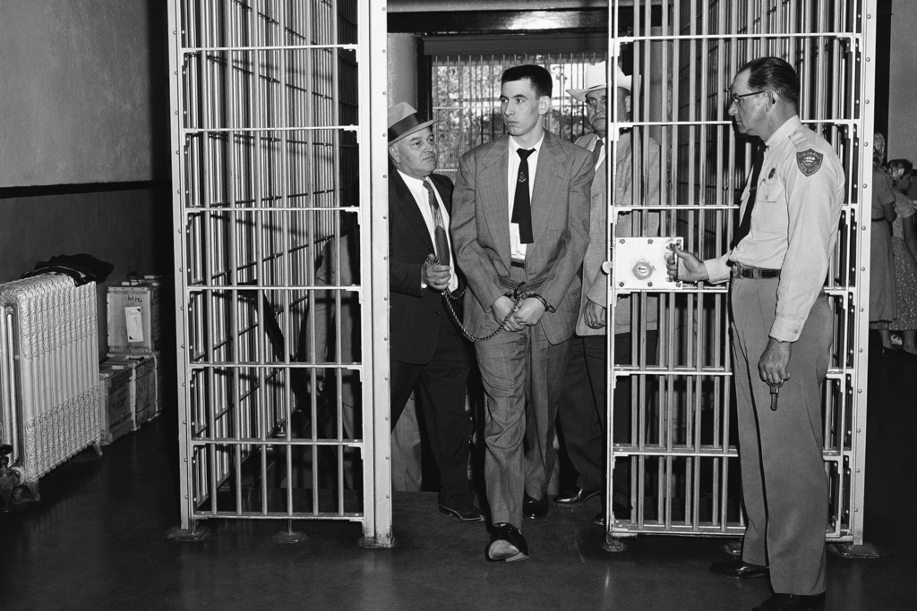 FILE - John Gilbert Graham, center, walks through a gate opened by a Colorado State Penitentiary guard, right, on Graham's way to death row in Canon City, Colo., May 15, 1956. (AP Photo)