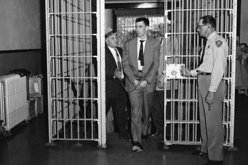 FILE - John Gilbert Graham, center, walks through a gate opened by a Colorado State Penitentiary guard, right, on Graham's way to death row in Canon City, Colo., May 15, 1956. (AP Photo) FILE - John Gilbert Graham, center, walks through a gate opened by a Colorado State Penitentiary guard, right, on Graham's way to death row in Canon City, Colo., May 15, 1956. (AP Photo)