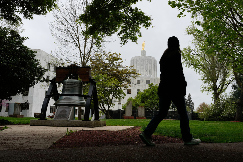 A person walks by a Liberty Bell replica at the Oregon state Capitol on Tuesday, April 14, 2026, in Salem, Ore. (AP Photo/Jenny Kane)