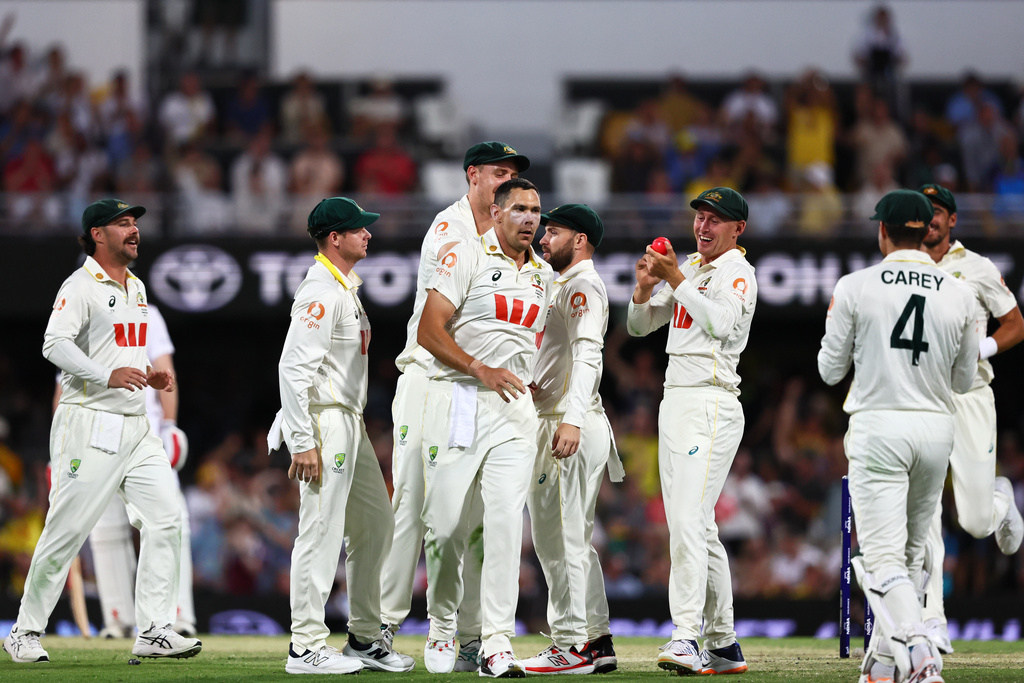 Australia's Scott Boland, centre, celebrates with teammates the wicket of England's Ben Duckett during the second Ashes cricket test match between Australia and England in Brisbane, Saturday, Dec. 6, 2025.. (AP Photo/Tertius Pickard)