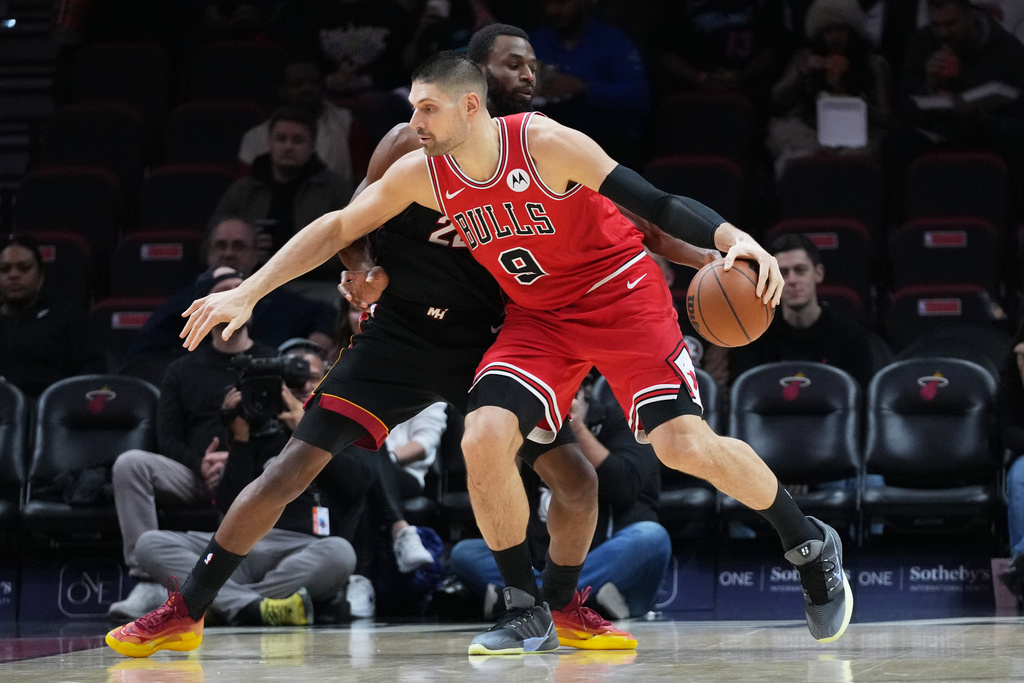 Chicago Bulls center Nikola Vucevic (9) controls the ball as Miami Heat forward Andrew Wiggins, left, defends during the first half of an NBA basketball game, Sunday, Feb. 1, 2026, in Miami. (AP Photo/Lynne Sladky)