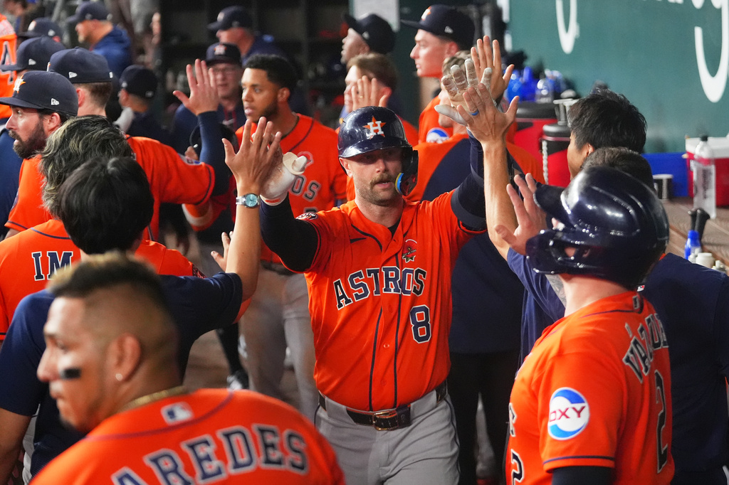 Houston Astros' Christian Walker (8) is greeted in the dugout after hitting a home run against the Texas Rangers during the seventh inning of a baseball game Monday, May 25, 2026, in Arlington, Texas. (AP Photo/Julio Cortez)