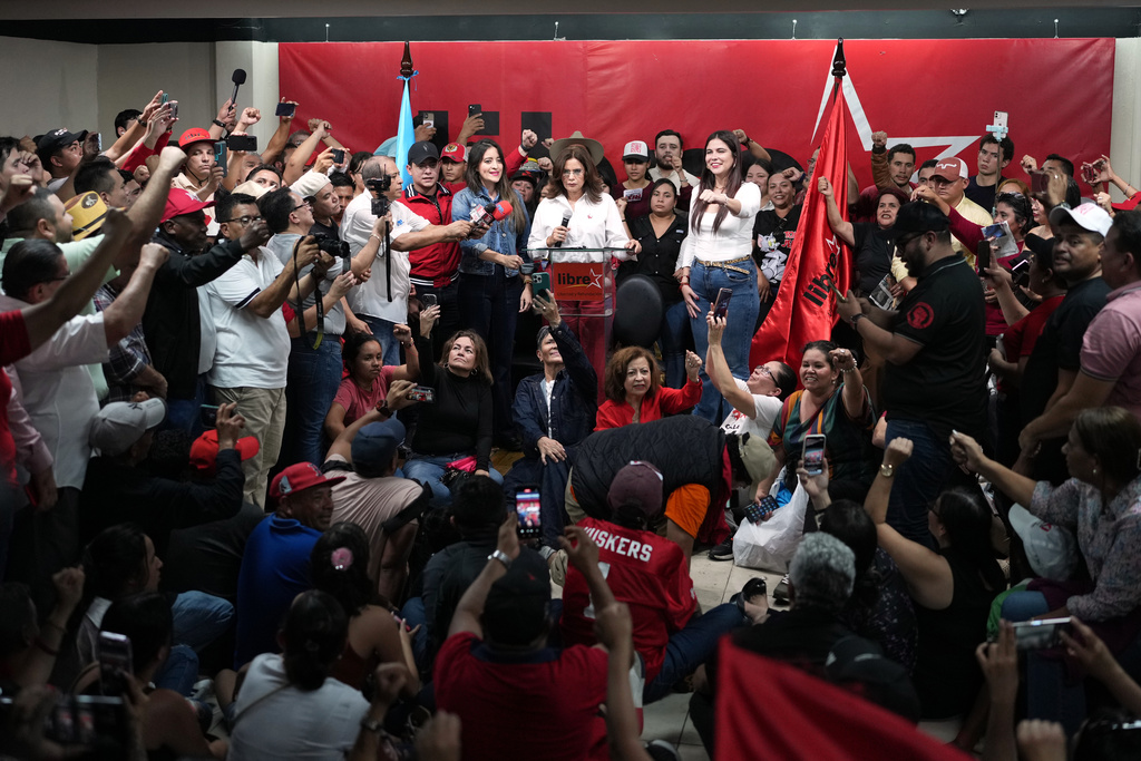 Supporters of the ruling party LIBRE, Liberty and Refoundation, cheer their presidential candidate Rixi Moncada, center top, at the party's headquarters in Tegucigalpa, Honduras, Sunday, Dec. 7, 2025. (AP Photo/Moises Castillo)