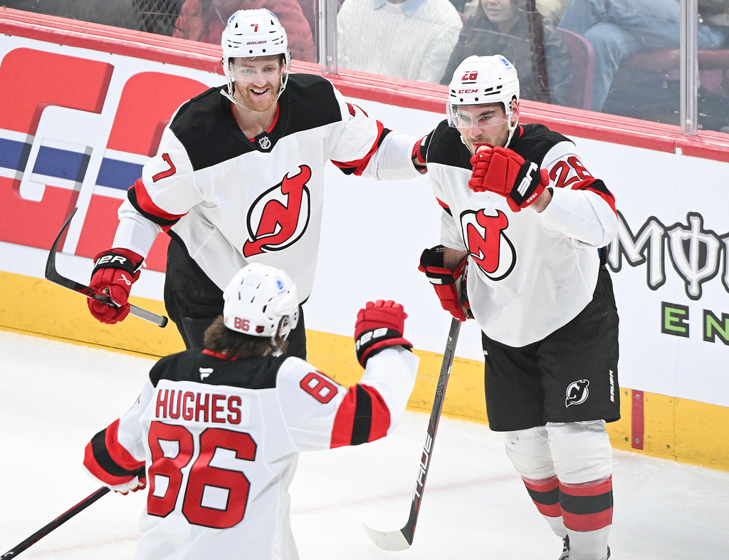 New Jersey Devils' Timo Meier (28) celebrates with teammates Dougie Hamilton (7) and Jack Hughes (86) after scoring against the Montreal Canadiens during the first period of an NHL hockey game in Montreal, Sunday, April 5, 2026. (Graham Hughes/The Canadian Press via AP)