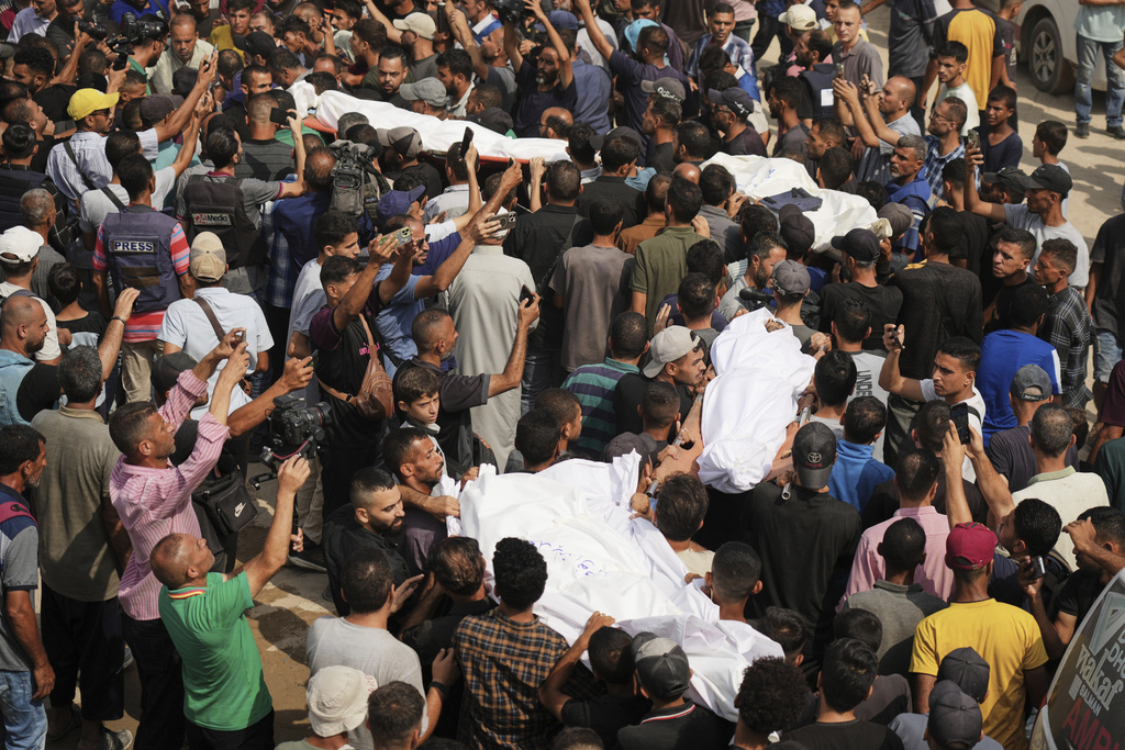 CORRECTS SURNAME TO QREIQEH, INSTEAD OF QUREIQA - Palestinians carry the bodies of journalists, including Al Jazeera correspondents Anas al-Sharif and Mohamed Qreiqeh, who were killed in an Israeli airstrike, during their funeral outside Gaza City's Shifa hospital complex, Monday, Aug. 11, 2025. (AP Photo/Jehad Alshrafi)