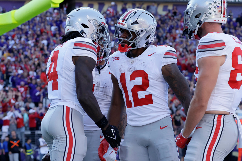 Ohio State wide receiver Jeremiah Smith (4) celebrates with running back CJ Donaldson (12) after scoring on a pass run play against the Washington during the first half of an NCAA college football game, Saturday, Sept. 27, 2025, in Seattle. (AP Photo/John Froschauer)