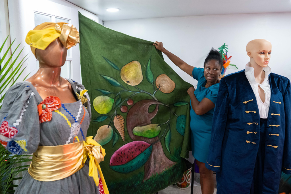 Haitian-born Clara Poteau holds up a Haitian costume for Lespri Ayiti Mas Camp, ahead of the West Indian Day Parade, Thursday, Sept. 3, 2026, in the Brooklyn borough of New York. (AP Photo/Adam Gray)
