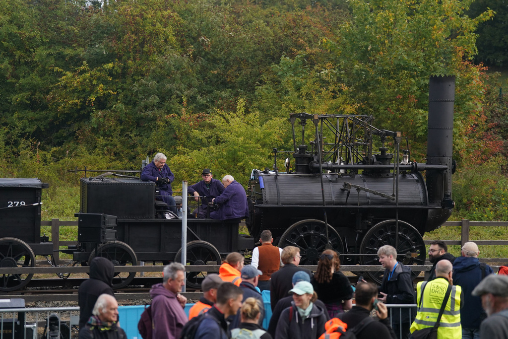 Railway enthusiasts look at the Locomotion No 1 replica as it is prepared at the Locomotion Museum in Shildon, County Durham, Friday, Sept. 26, 2025, on its first official journey in 200 years from the Locomotion Museum in Shildon to Darlington, as part of celebrations marking the 200th anniversary of British passenger rail services. (Owen Humphreys/PA via AP)