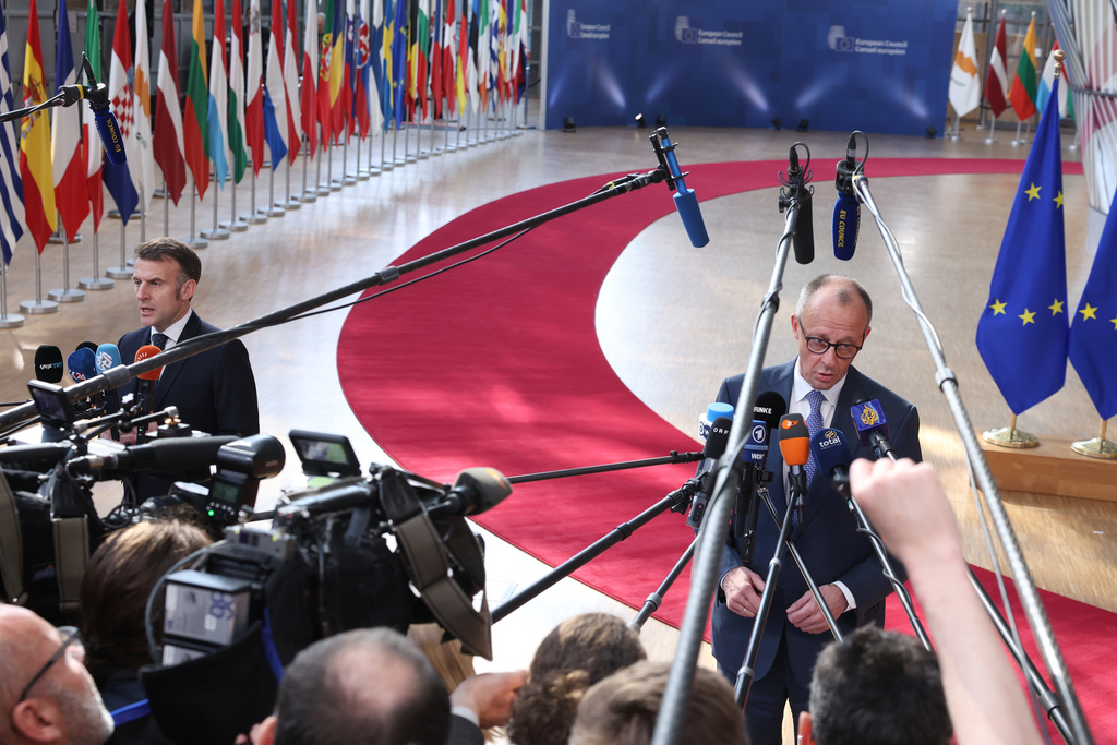 Germany's Chancellor Friedrich Merz, right, and French President Emmanuel Macron, left, speak with the media as they arrive for the EU summit at the European Council building in Brussels, Thursday, March 19, 2026. (AP Photo/Omar Havana)