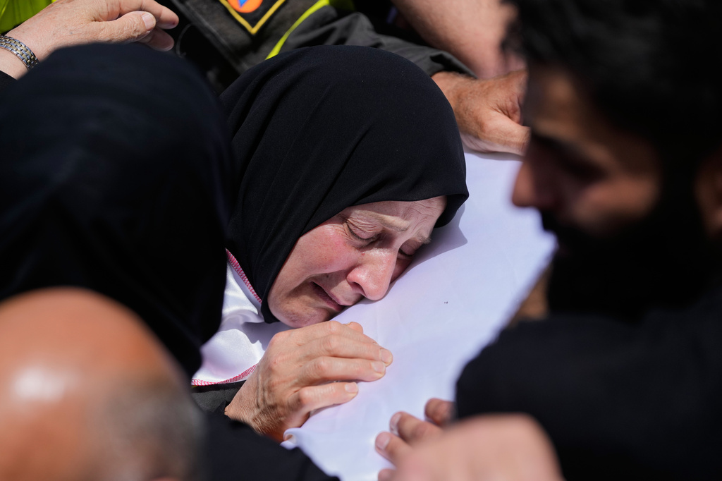 A mourner reacts over the coffin of Lebanese Civil Defense member, Hussein Jaber, who was killed on Tuesday in an Israeli airstrike during a funeral procession in the coastal city of Sidon, Lebanon, Wednesday, May 13, 2026. (AP Photo/Mohammed Zaatari)