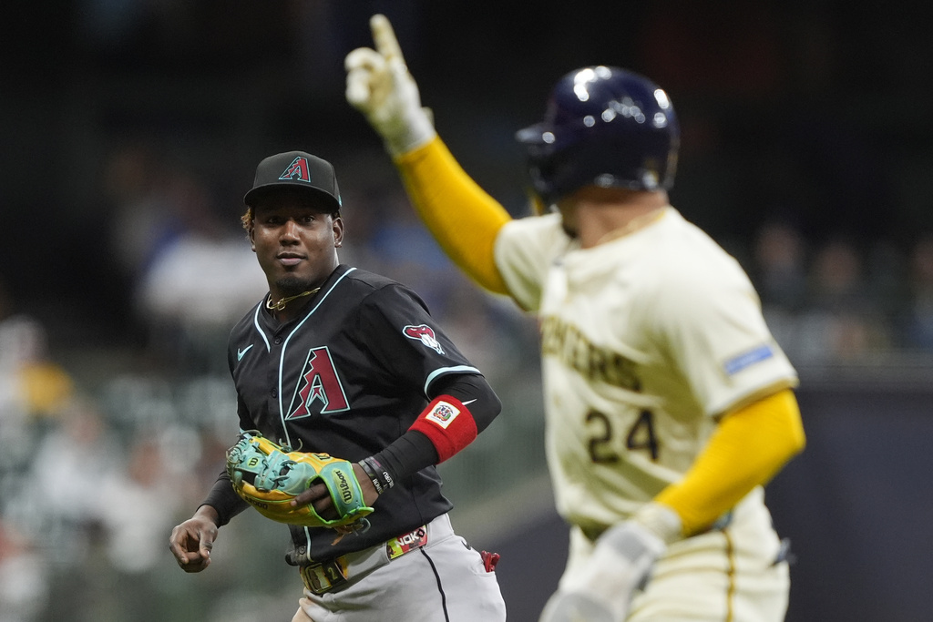 Arizona Diamondbacks' Geraldo Perdomo, left, talks with Milwaukee Brewers' William Contreras (24) during the fourth inning of a baseball game Monday, Aug. 25, 2025, in Milwaukee. (AP Photo/Aaron Gash)