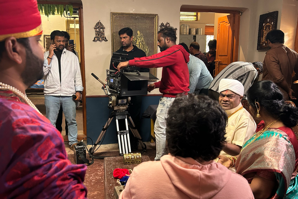 Filmmaker T.V. Ravi Narayan, left white jacket, is seen with Director of Photography Rahul Shrivatsav, second left, and the crew and artists on the sets of a movie at Ramoji Film City, in Hyderabad, India, Tuesday, Nov. 18, 2025. (AP Photo/Mahesh Kumar A.)