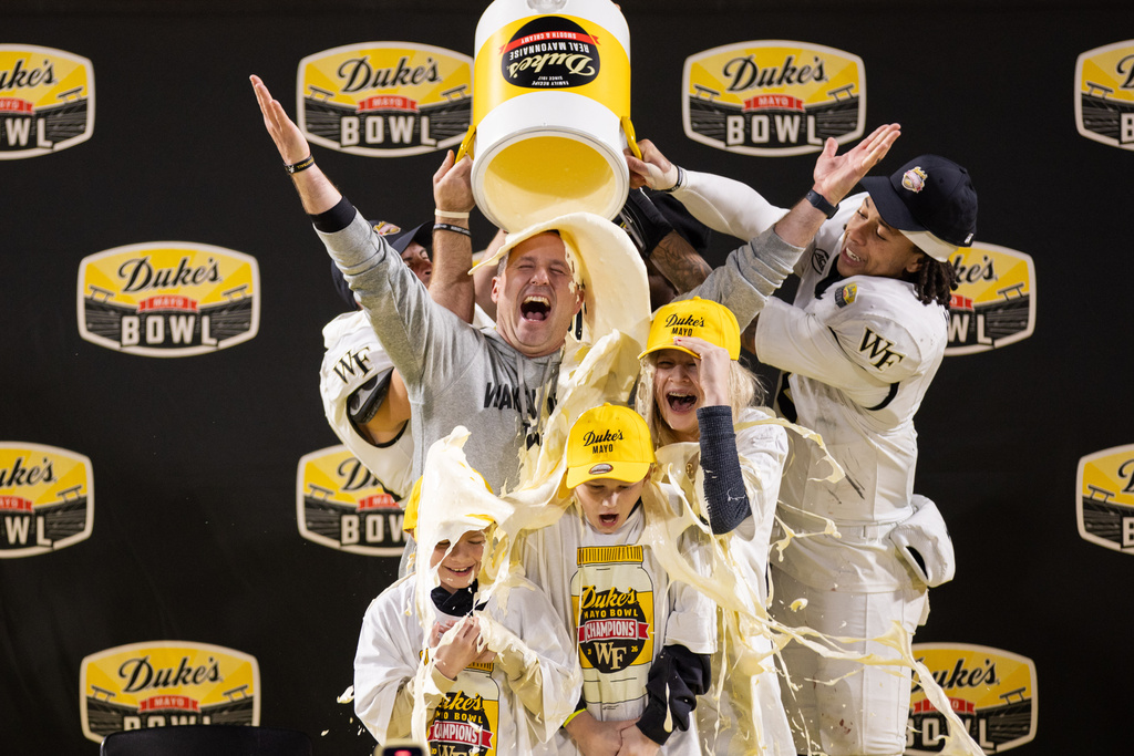 Wake Forest head coach Jake Dickert gets dunked in mayo with his children after winning the Duke's Mayo Bowl NCAA college football game, Saturday, Jan. 3, 2026, in Charlotte, N.C. (AP Photo/Scott Kinser)