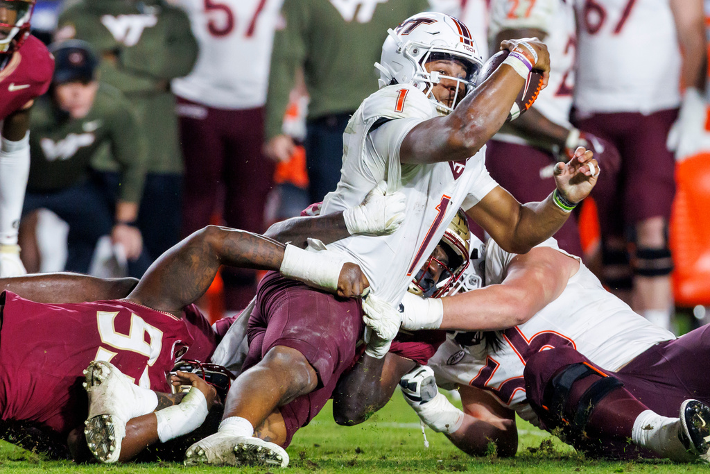 Virginia Tech quarterback Kyron Drones (1) is tackled by Florida State defensive lineman Mandrell Desir (93) and Omar Graham Jr. during the second half of an NCAA college football game, Saturday, Nov. 15, 2025, in Tallahassee, Fla. (AP Photo/Colin Hackley)