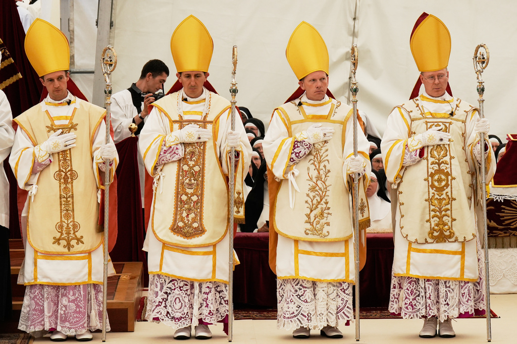 Newly consecrated bishops, from left, Marc Hanappier, Michel Poinsinet de Sivry, Michael Goldade and Pascal Schreiber wearing their miters and holding their pastoral staffs, stand at the end of their consecration ceremony in a tent set up outside the Society of St. Pius X seminary in Econe, Switzerland, Wednesday, July 1, 2026. (AP Photo/Baz Ratner)