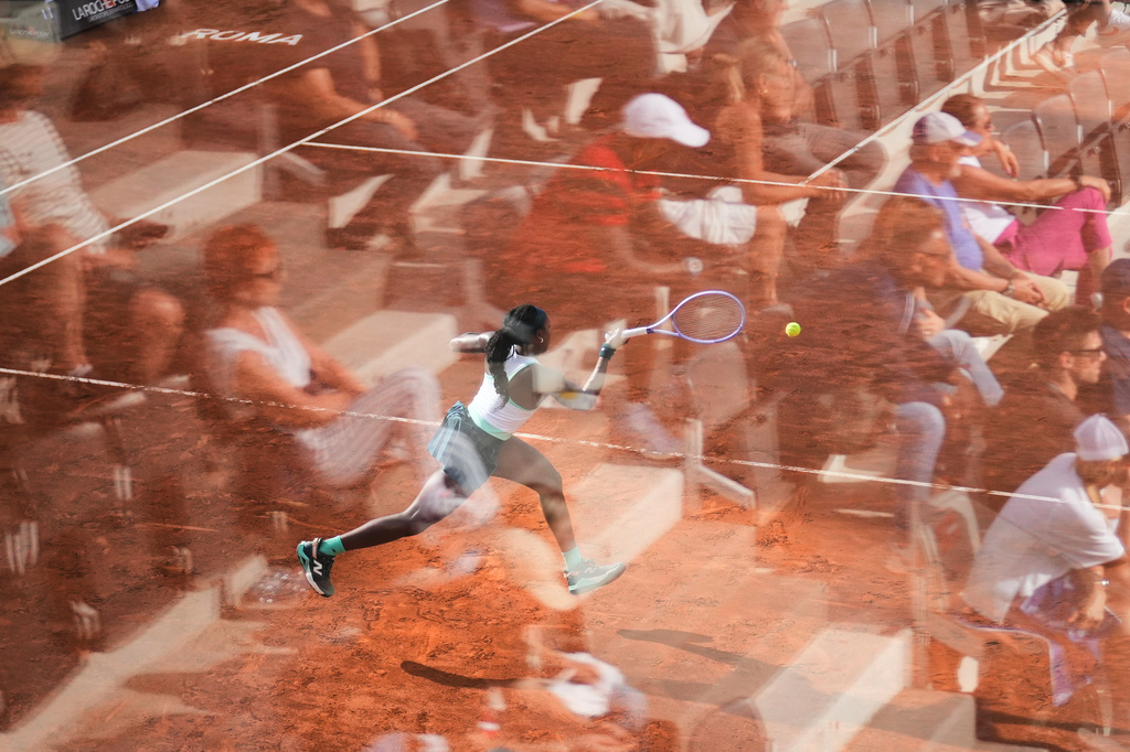 Fans are reflected in a glass partition as Coco Gauff, of the United States, returns the ball to Tereza Valentova, of the Czech Republic, during their match at the Italian Open tennis tournament in Rome, Thursday, May 7, 2026. (AP Photo/Alessandra Tarantino)