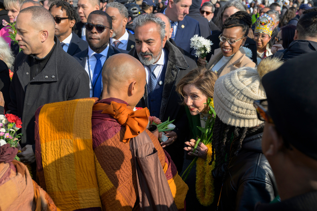 House Minority Leader Hakeem Jeffries, D-N.Y. , left, and Rep. Nancy Pelosi, D-Calif., right, greet Buddhist monks as they walk near the Peace Monument on Capitol Hill, during the Walk for Peace, in Washington, Wednesday, Feb., 11, 2026. (AP Photo/Rod Lamkey, Jr.)