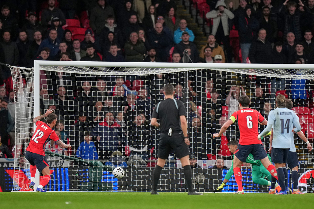 England's Ben White, left, scores his side's opening goal during the international friendly soccer match between England and Uruguay in London, Friday, March 27, 2026. (AP Photo/Alastair Grant)