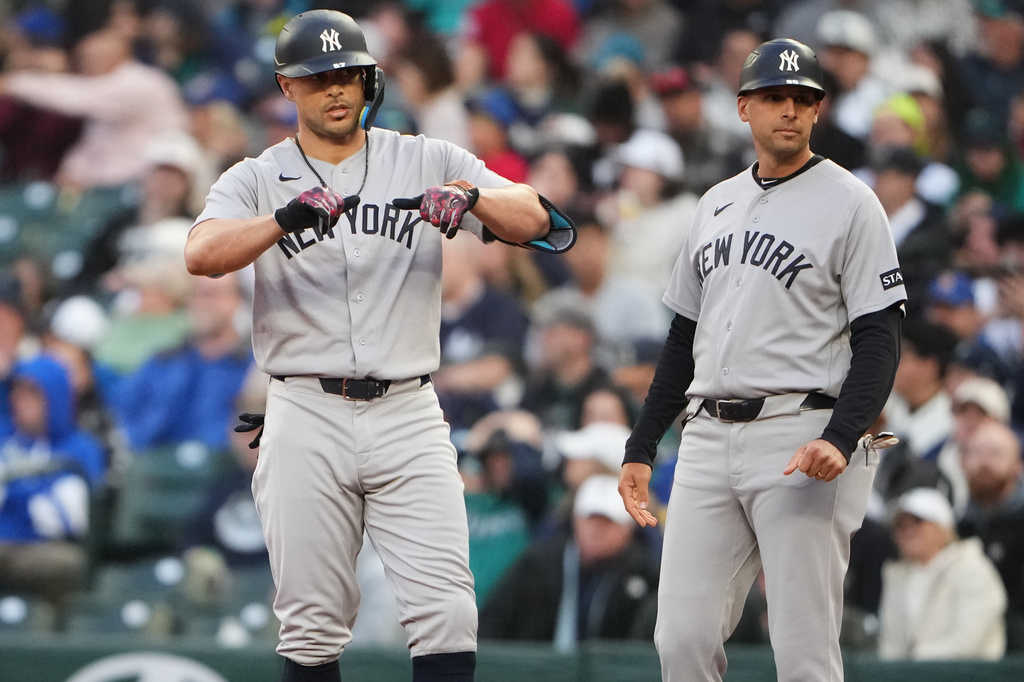 New York Yankees designated hitter Giancarlo Stanton reacts after hitting an RBI single against the Seattle Mariners during the first inning of a baseball game, Tuesday, March 31, 2026, in Seattle. (AP Photo/Lindsey Wasson)