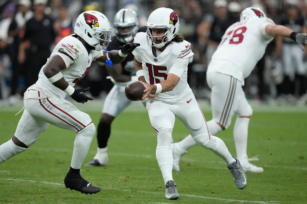 Arizona Cardinals quarterback Gardner Minshew II (15) hands the ball off to Cardinals running back Jeremiyah Love (4) during the first half of a preseason NFL football game, Thursday, Aug. 13, 2026, in Las Vegas. (AP Photo/John Locher)