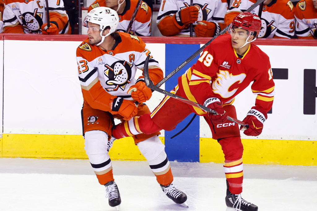 Anaheim Ducks' Mason McTavish, left, gets tangled with Calgary Flames' Zayne Parekh during the first period of an NHL hockey game in Calgary, Alberta, Thursday, March 26, 2026. (Larry MacDougal/The Canadian Press via AP)